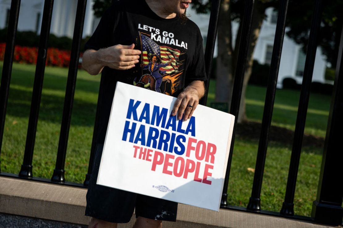 Un hombre con una camiseta de "Let's Go Kamala" sostiene un cartel de apoyo a la vicepresidenta de EE.UU., Kamala Harris, a lo largo de la Avenida Pennsylvania frente a la Casa Blanca en la ciudad de Washington, el 21 de julio de 2024.