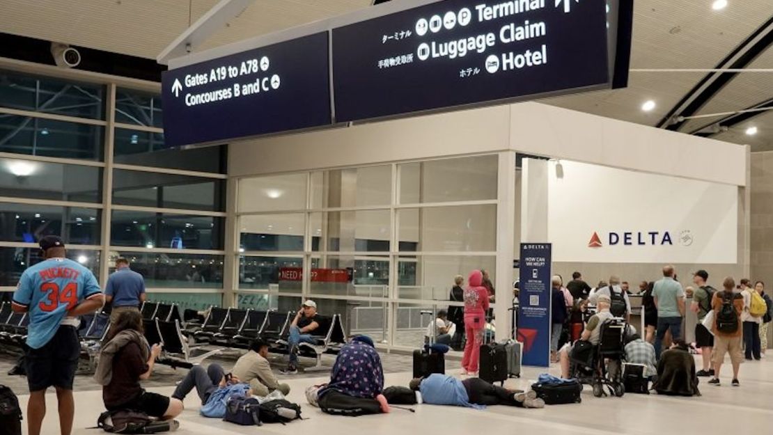 Viajeros esperan en una larga cola para hablar con un representante de Delta en el mostrador de ayuda de la terminal McNamara del Aeropuerto Metropolitano Wayne County de Detroit el 20 de julio en Detroit, Michigan.