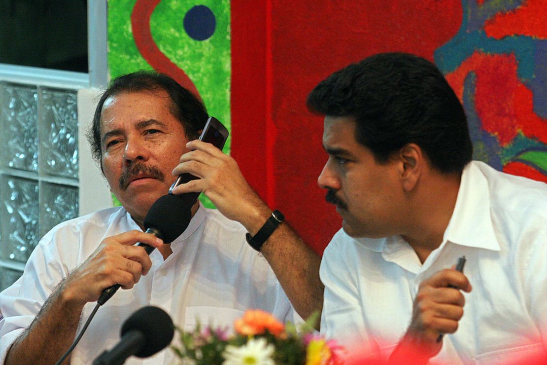 El presidente de Nicaragua, Daniel Ortega, habla por teléfono móvil con su homólogo venezolano, Hugo Chávez, junto al ministro de Relaciones Exteriores, Nicolás Maduro (derecha), el 19 de octubre de 2007, durante una reunión en la sede del Frente Sandinista de Liberación Nacional (FSLN).