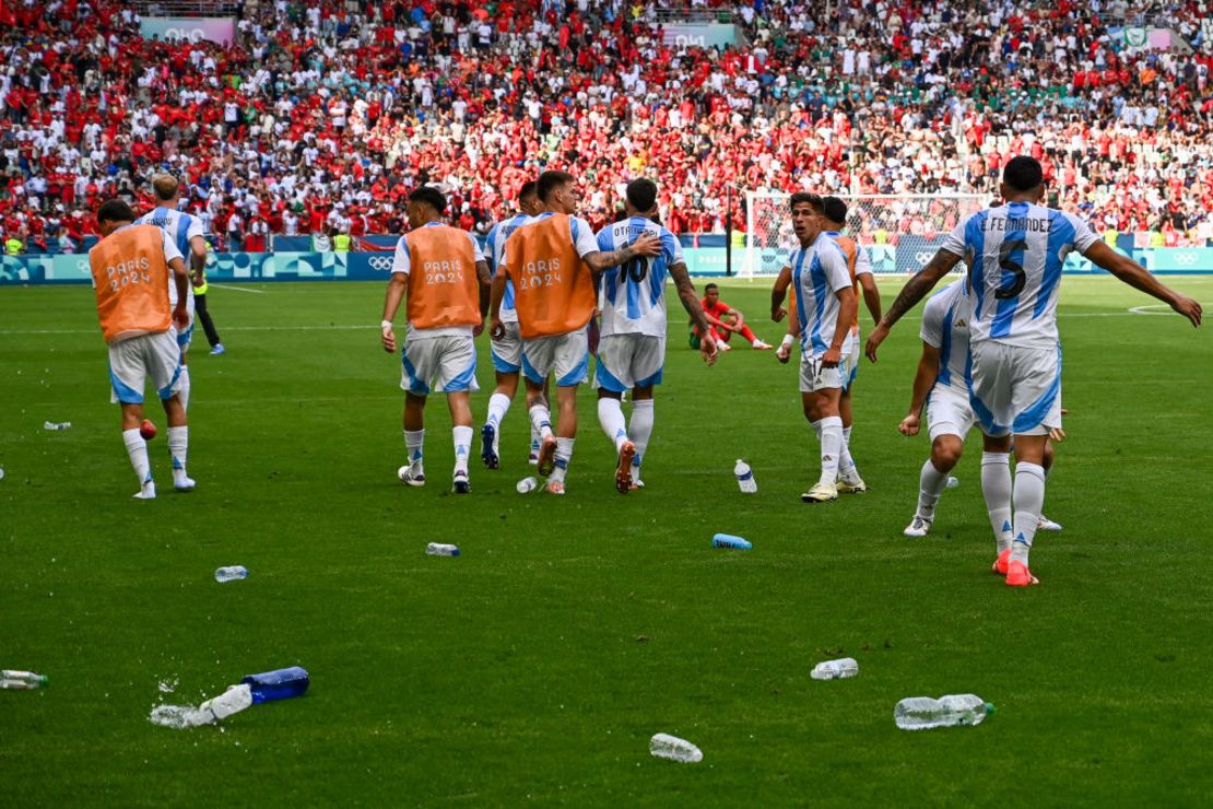 El delantero argentino Giuliano Simeone observa cómo las botellas de agua arrojadas por los seguidores de Marruecos inundan el campo después de que Argentina anotó su segundo gol, que fue anulado después Crédito: ARNAUD FINITRE/AFP vía Getty Images