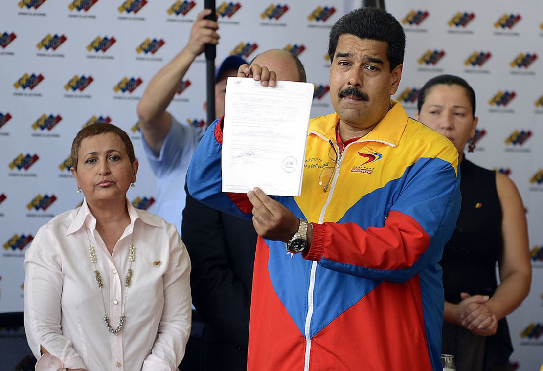 El presidente encargado de Venezuela, Nicolás Maduro, muestra los documentos de su registro oficial como candidato para las próximas elecciones presidenciales en el Consejo Nacional Electoral (SNE) en Caracas, el 11 de marzo de 2013.