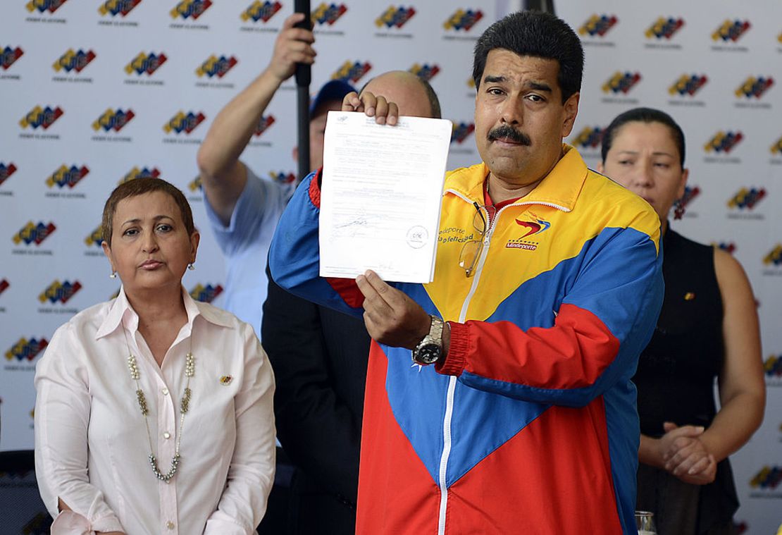 El presidente encargado de Venezuela, Nicolás Maduro, muestra los documentos de su registro oficial como candidato para las próximas elecciones presidenciales en el Consejo Nacional Electoral (CNE) en Caracas, el 11 de marzo de 2013.