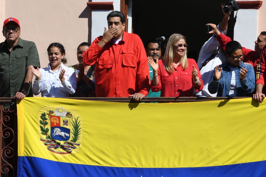 El presidente de Venezuela, Nicolás Maduro (centro), flanqueado por su esposa Cilia Flores (derecha), lanza un beso desde un balcón del Palacio de Miraflores a una multitud de seguidores durante la Marcha Internacional Antiimperialista en Caracas, el 23 de enero de 2020. -