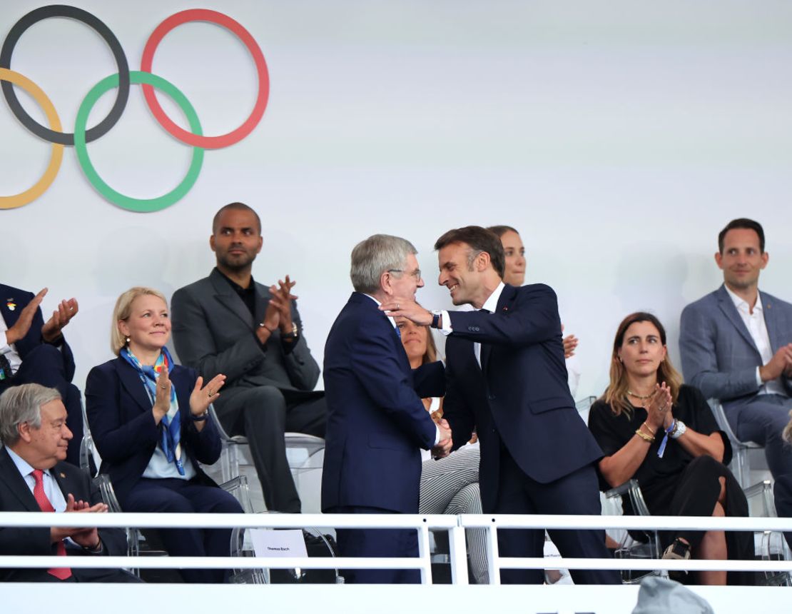 El presidente de Francia, Emmanuel Macron, y Thomas Bach, presidente del Comité Olímpico Internacional (COI), se dan la mano durante la ceremonia de apertura de los Juegos Olímpicos de París 2024 en la Place du Trocadero el 26 de julio de 2024 en París, Francia.