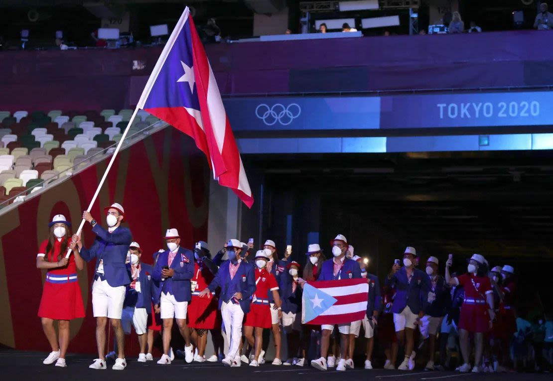 Los abanderados Adriana Díaz y Brian Afanador del equipo de Puerto Rico caminan con su equipo durante la ceremonia de apertura de los Juegos Olímpicos de Tokio 2020.