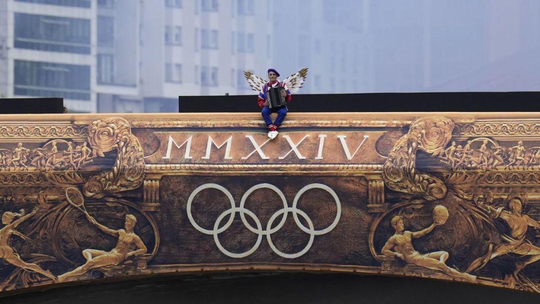 Un artista sentado en un puente en París durante la ceremonia de apertura. (Foto: Kirsty Wigglesworth/AP).