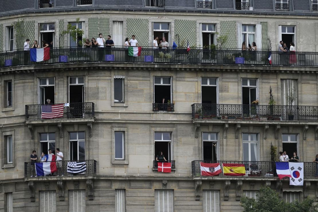 La gente se para en los balcones de París para ver la ceremonia. Luca Bruno/AP.