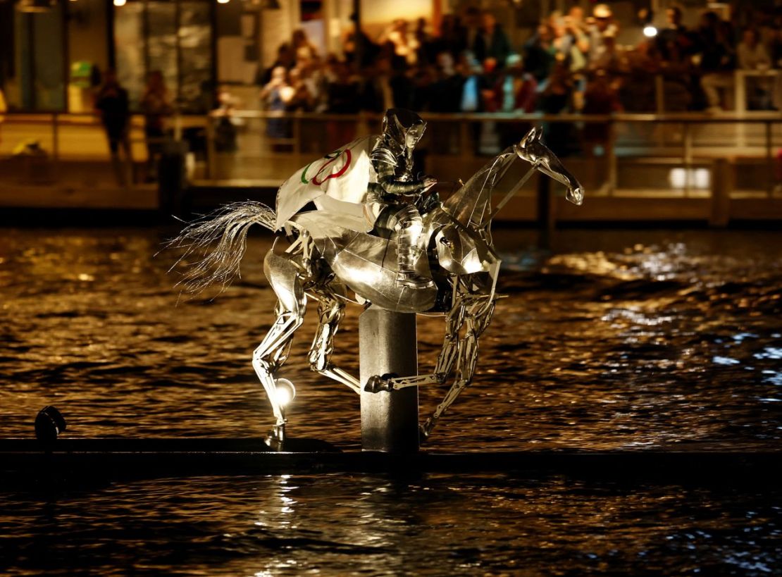 Durante la ceremonia de apertura se ve a una persona montada en un caballo robótico que lleva una bandera que muestra los anillos olímpicos. (Foto: Adnan Abidi/Reuters).