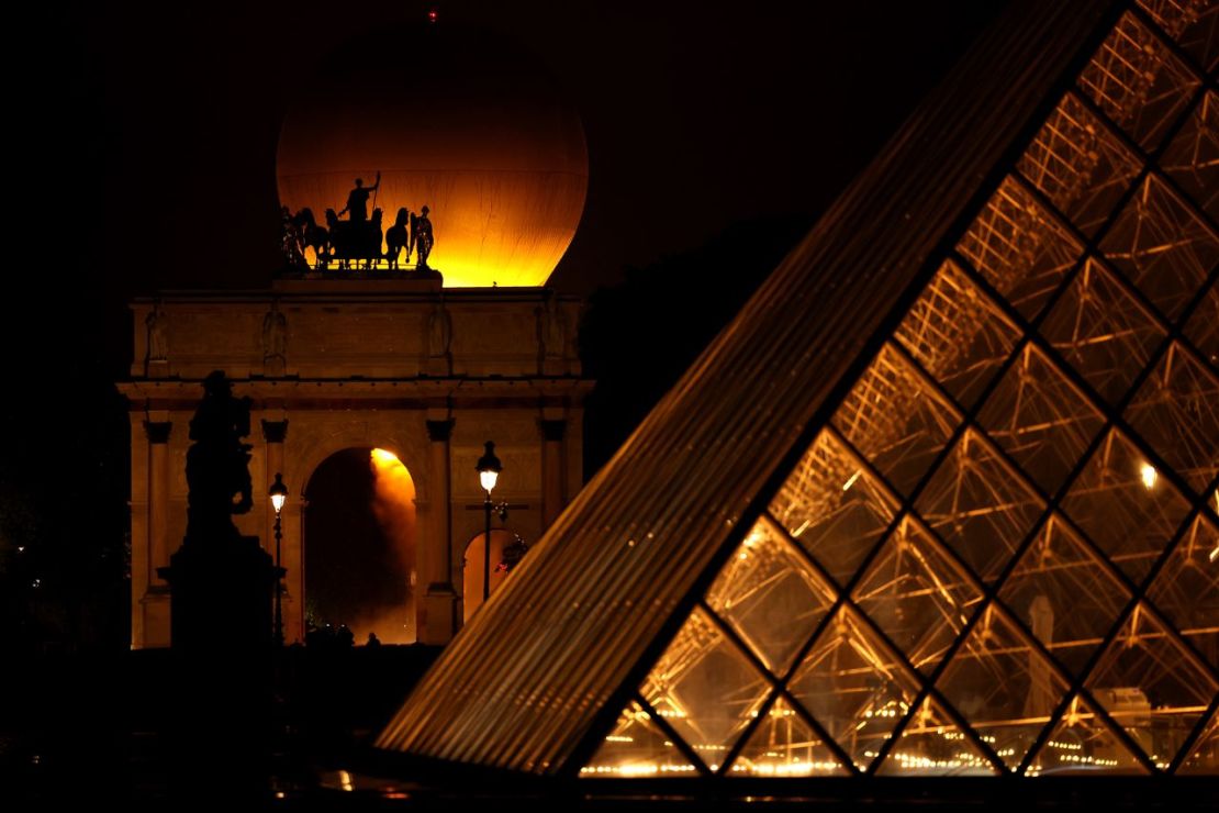 Una vista detallada del pebetero olímpico en el cielo detrás del Arco de Triunfo del Carrusel y la pirámide del Louvre después de ser encendido por los portadores de la antorcha, la atleta sa Marie-Jose Perec y el judoca francés Teddy Riner. (Foto: Getty Images).