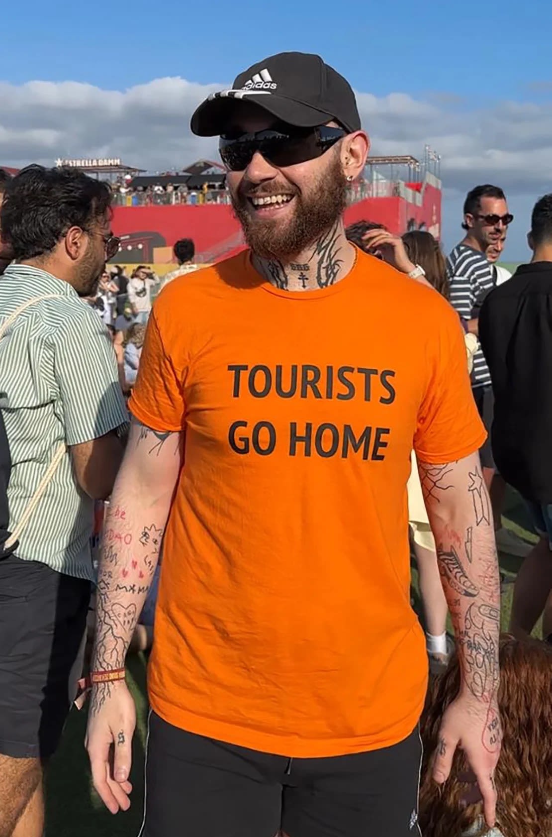 Carlos Ramírez, un profesor de 26 años, asiste al festival de música Primavera Sound en Barcelona, ​​España, vistiendo una camiseta que dice “Los turistas se van a casa”.