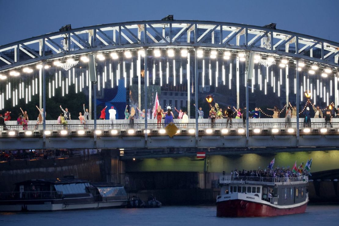 Los artistas se ven en una pasarela erigida a lo largo del puente Passerelle Debilly en París durante la ceremonia de apertura.