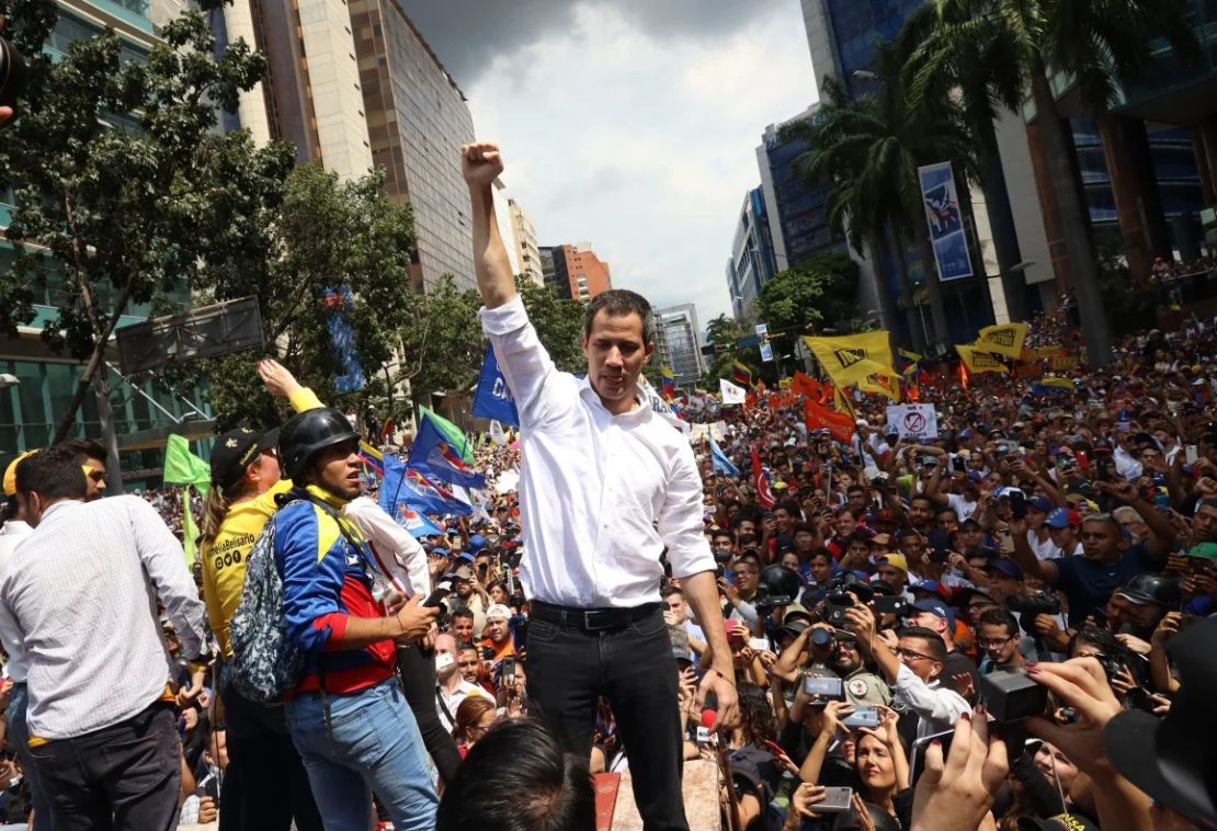 El líder opositor Juan Guaidó saluda a sus partidarios frente a la Embajada de Bolivia en Caracas, Venezuela, durante una manifestación llamada "Despierta, Venezuela" para presionar al presidente Nicolás Maduro para que renuncie el 16 de noviembre de 2019.