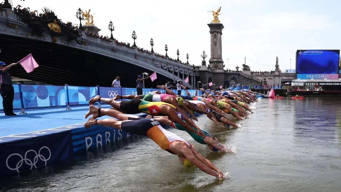 Los atletas se lanzan al río Sena para comenzar la etapa de natación del triatlón individual masculino en los Juegos Olímpicos de París 2024 en el centro de París el 31 de julio de 2024.