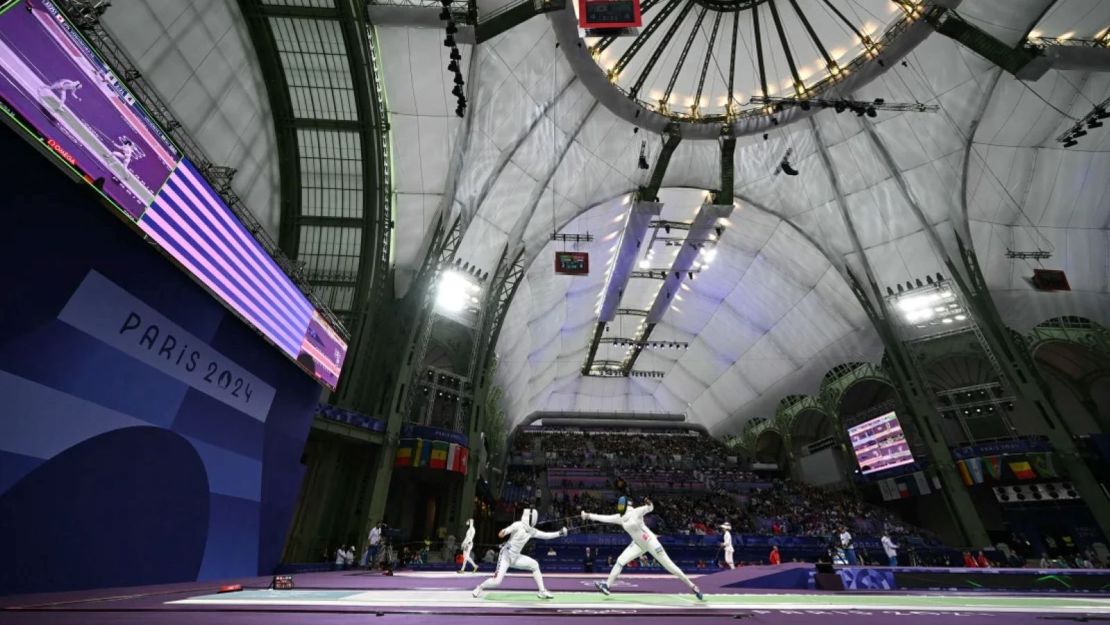 Miho Yoshimura de Japón (centro izquierda) compite contra Tufaha Uwihoreye de Ruanda en el combate de la ronda de 64 de la espada femenina durante los Juegos Olímpicos de París 2024 en el Grand Palais en París, el 27 de julio de 2024.