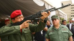 TOPSHOT - El presidente venezolano Hugo Chávez apunta con un fusil de asalto AK-103 de fabricación rusa recientemente adquirido el 14 de junio de 2006 durante una ceremonia celebrada en el Ministerio de Defensa en Caracas. El fusil AK-103 forma parte del primer lote de 33.000 de un total de 100.000 adquiridos por Venezuela para equipar a sus fuerzas armadas. En Venezuela el aumento de los ingresos públicos, procedentes del petróleo, se ha traducido también en un incremento del gasto militar, que ha experimentado el mayor aumento de la región después de los de Brasil y Chile. AFP PHOTO PRESIDENCIA