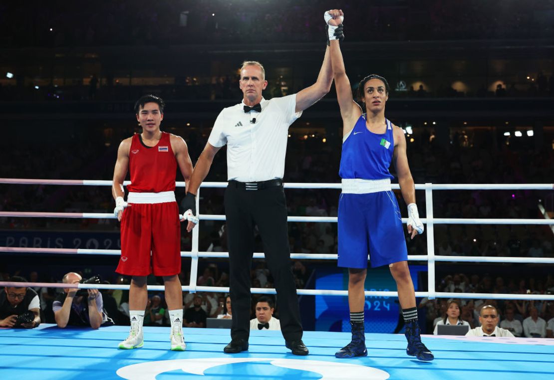 Janjaem Suwannapheng de Tailandia observa mientras el árbitro del combate Shawn Reese levanta el brazo de Imane Khelif de Argelia para anunciar a la ganadora de la semifinal de boxeo de 66 kg femenino, en el día 11 de los Juegos Olímpicos de París 2024.