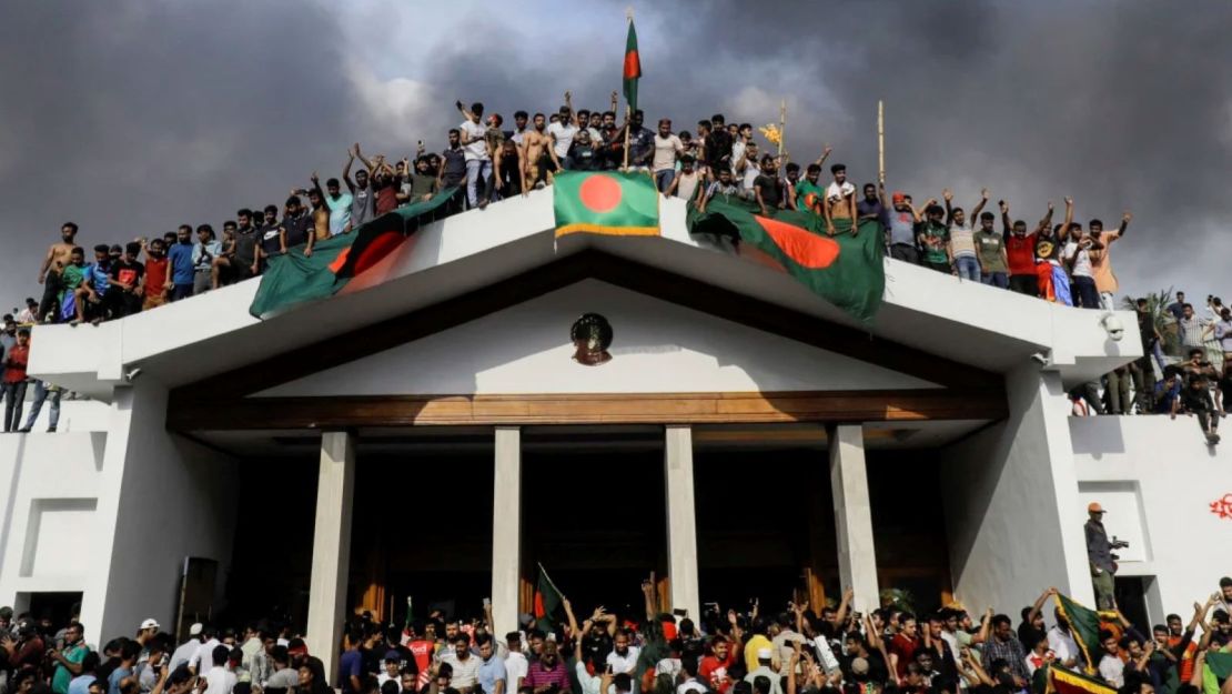 Manifestantes antigubernamentales exhiben la bandera nacional de Bangladés después de asaltar el palacio de la ex primera ministra Sheikh Hasina en Dhaka el 5 de agosto de 2024.