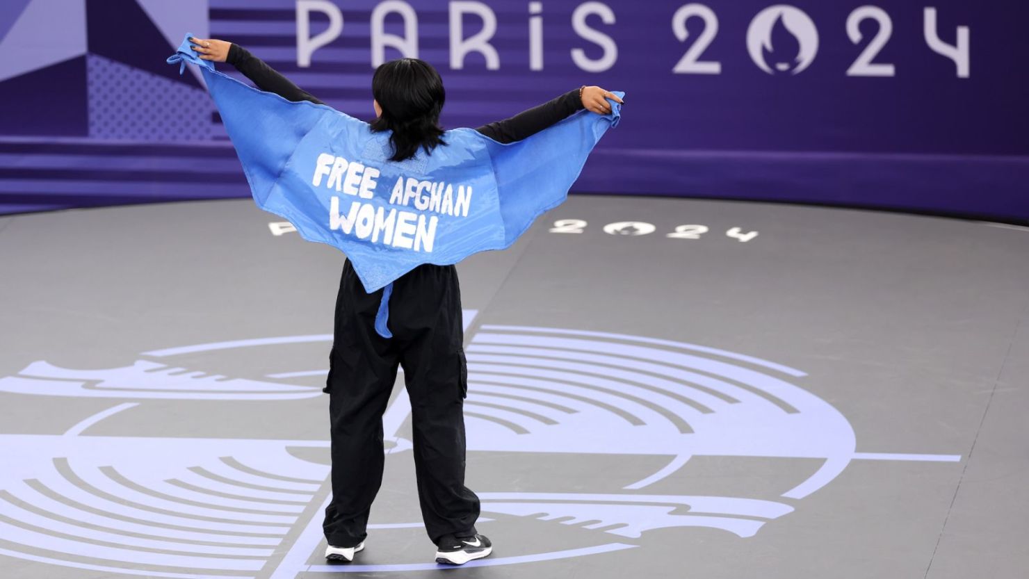 La B-girl Talash, del equipo olímpico de refugiados, compite con una capa que dice "liberen a las mujeres afganas libres" durante la preclasificatoria de B-girls el viernes.