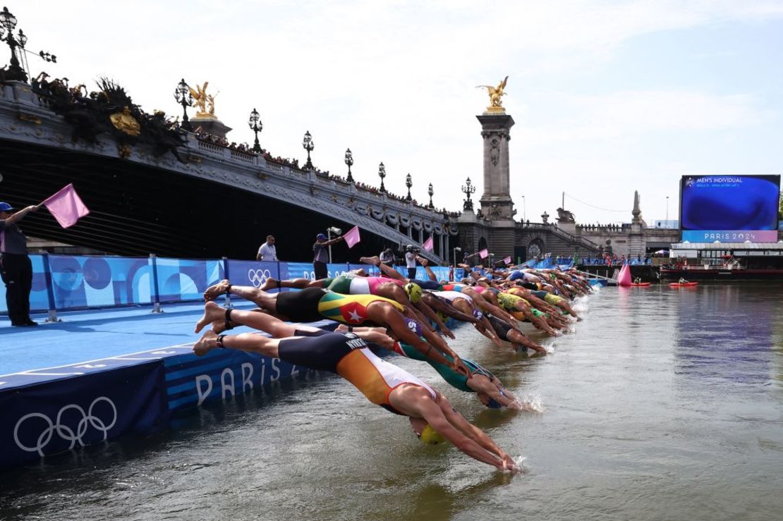 Unos atletas se zambullen en el río Sena para comenzar la etapa de natación del triatlón individual masculino de los Juegos Olímpicos de París 2024, en el centro de París, el 31 de julio de 2024. Crédito: Anne-Christine Poujoulat/AFP/Getty Images