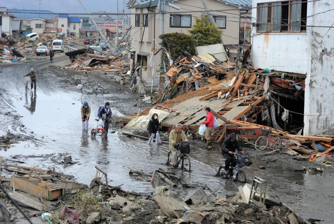 Residentes pasan por una calle devastada en Ishinomaki, prefectura de Miyagi, después de que Japón fuera golpeado por un devastador terremoto y tsunami, el 15 de marzo de 2011. Crédito: Kim Jae-Hwan/AFP/Getty Images