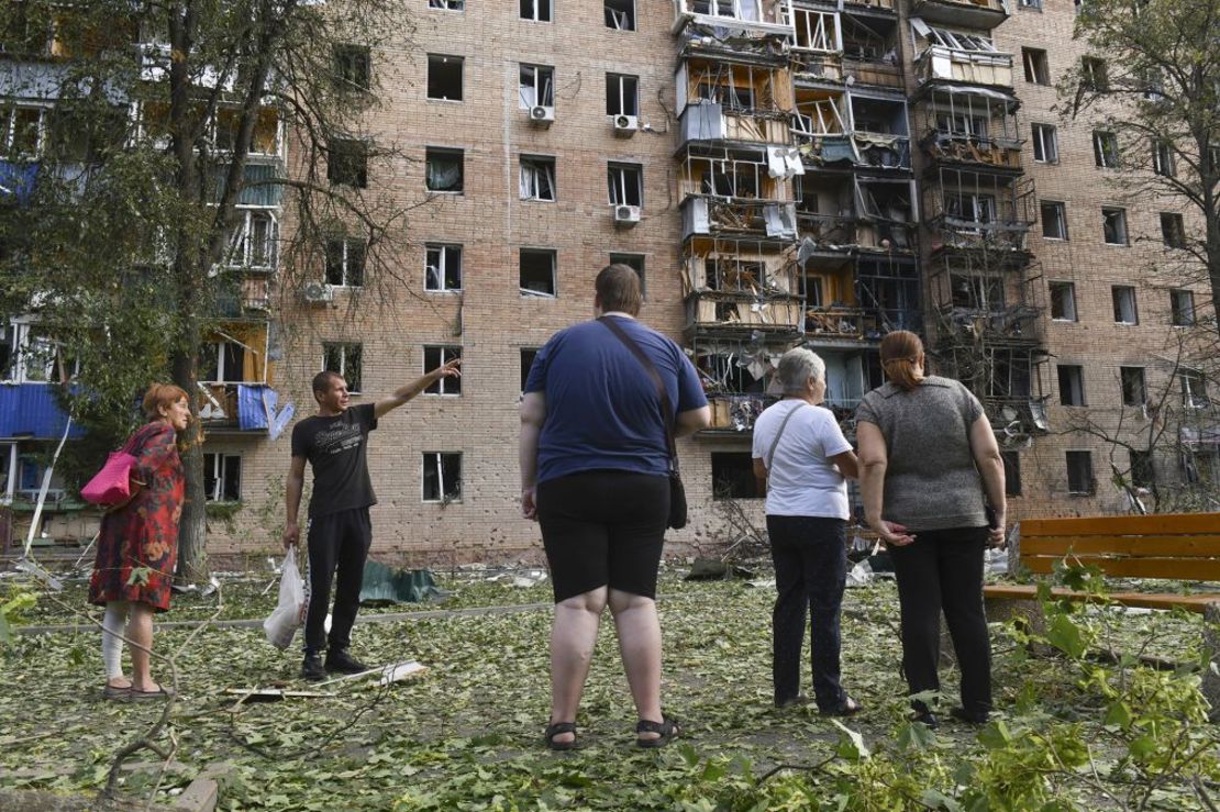 Los residentes de un edificio de departamentos dañado tras el bombardeo de la parte ucraniana se paran cerca del edificio en Kursk, Rusia, el domingo. Crédito: AP