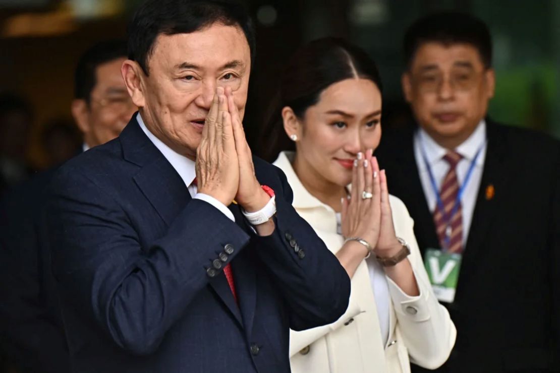 El ex primer ministro tailandés Thaksin Shinawatra saluda a sus seguidores, junto a su hija menor Paetongtarn Shinawatra, en el aeropuerto Don Mueang de Bangkok el 22 de agosto de 2023.