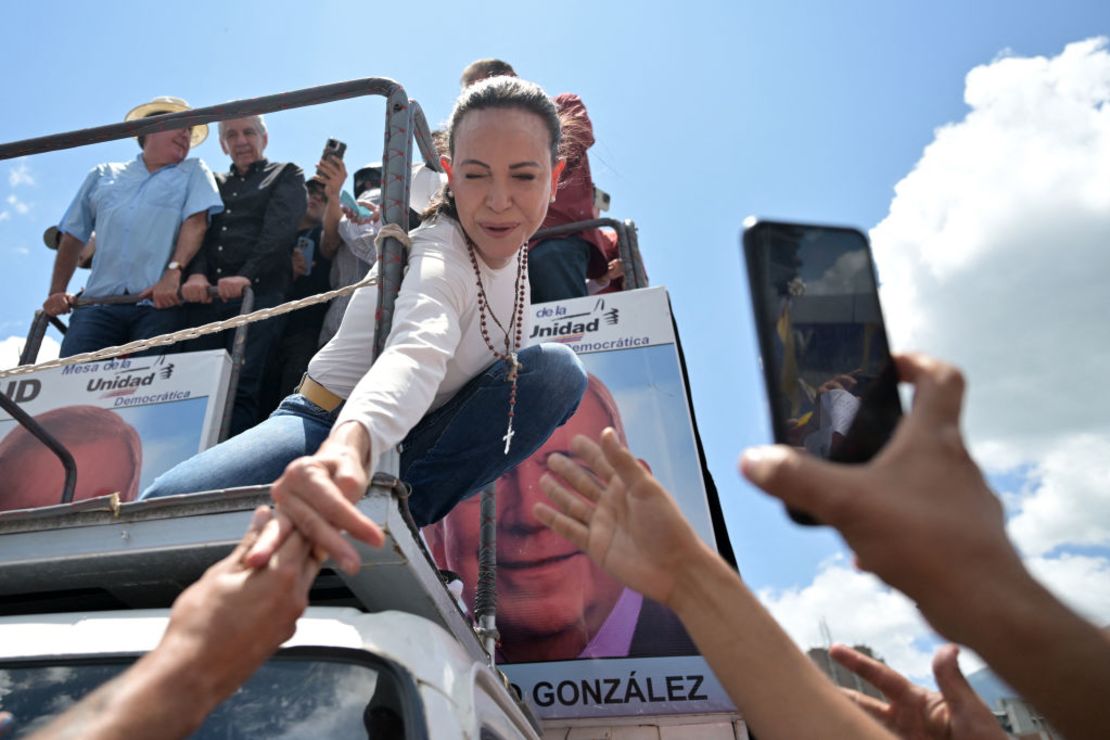 La líder opositora Maria Corina Machado saluda a sus seguidores desde su camión durante la marcha en Caracas el 17 de agosto de 2024.