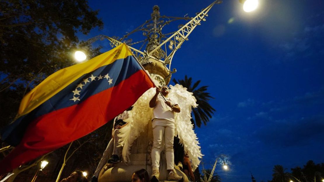 Una persona ondea una bandera venezolana mientras miles de personas se manifiestan después de un llamado a protestas globales contra los resultados de las disputadas elecciones en Venezuela, el 17 de agosto de 2024 en Barcelona.