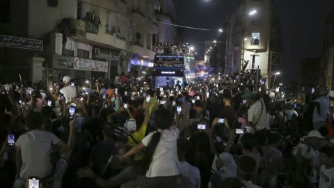 La gente se reúne en las calles mientras la medallista de oro olímpica Imane Khelif saluda desde lo alto de un autobús de dos pisos.