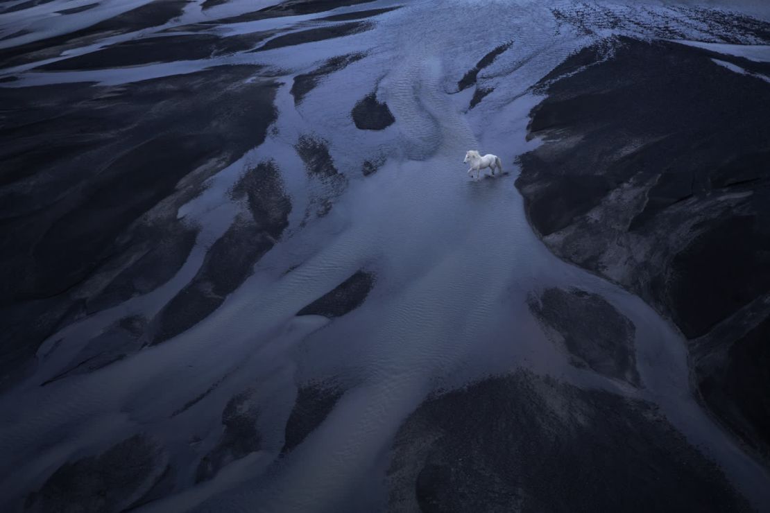 Un caballo islandés atraviesa una playa de arena negra. Islandia es "el hogar de estas extraordinarias características naturales que casi desafían a la realidad", dijo Doggett.