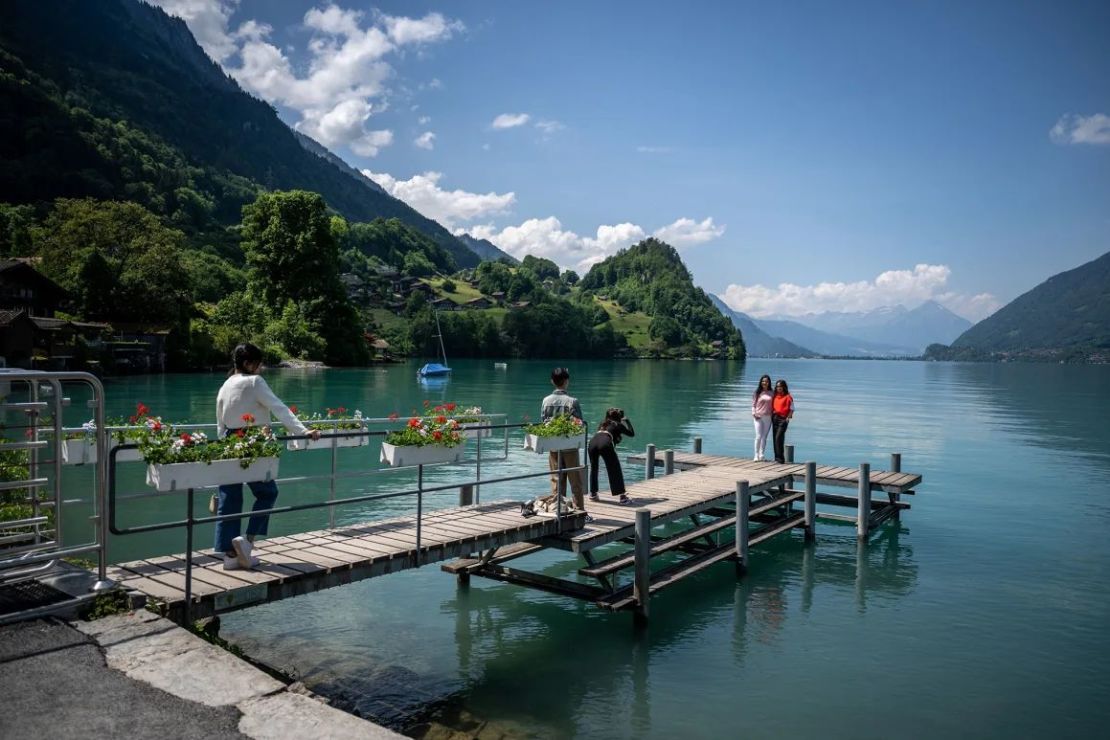 Turistas son fotografiados en el lago de Brienz en los Alpes suizos. Crédito: Fabrice Coffrini/AFP/Getty Images.