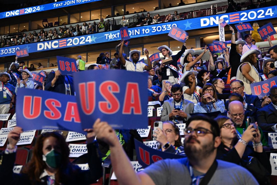 La gente sostiene carteles con el nombre de Estados Unidos al inicio de la convención, que se lleva a cabo en el United Center de Chicago. Crédito: Austin Steele/CNN.