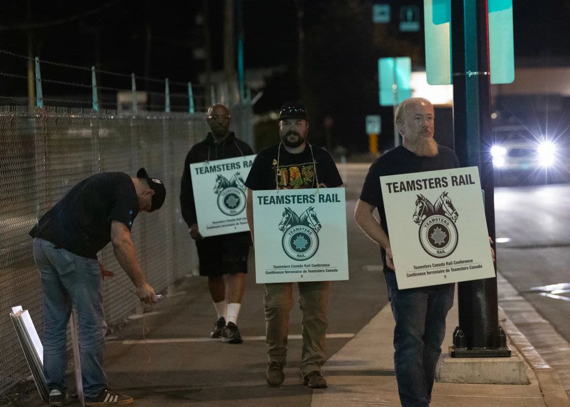 Teamsters union members hold picket signs at the entrance to CN Rail's Lynn Creek shunting yard in North Vancouver, British Columbia, Canada, on Wednesday.