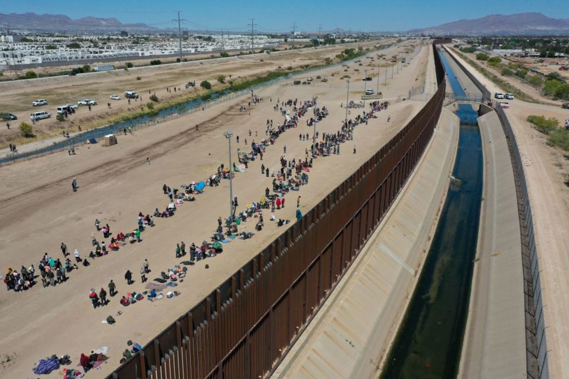 Una imagen aérea muestra a migrantes esperando a lo largo del muro fronterizo para entregarse a los agentes de la patrulla fronteriza de Aduanas y Protección Fronteriza (CBP) de Estados Unidos el 11 de mayo de 2023. Crédito: PATRICK T. FALLON/AFP vía Getty Images