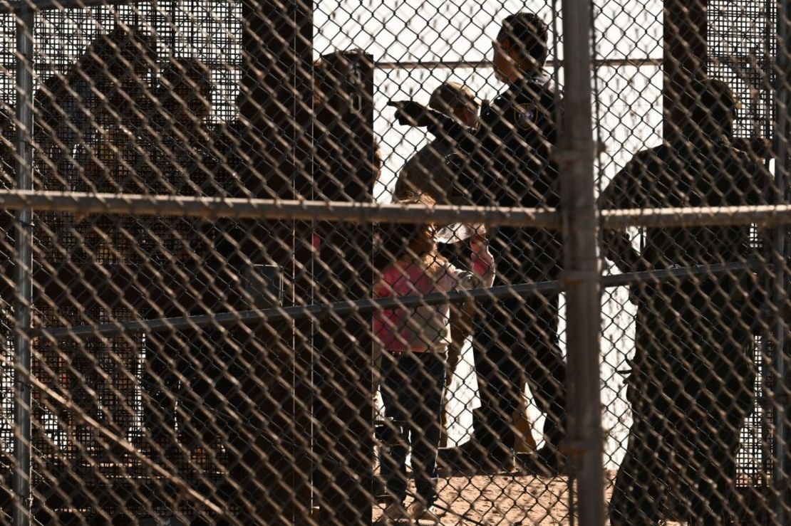 Una niña bebe de una botella de agua mientras los migrantes abordan camionetas de la Patrulla Fronteriza el 11 de mayo de 2023. Crédito: PATRICK T. FALLON/AFP vía Getty Images