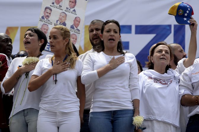 La alcaldesa de San Cristóbal, Patricia Gutiérrez de Ceballos, esposa de Daniel Ceballos; Lilian Tintori, esposa de Leopoldo López y la exdiputada María Corina Machado cantan el himno nacional de Venezuela durante la manifestación de la oposición en Caracas.