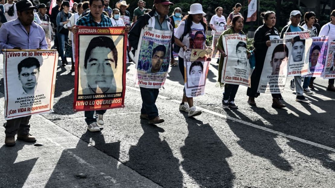 Familiares de víctimas de Ayotzinapa y estudiantes participan en una marcha para exigir justicia en el caso de la desaparición de 43 estudiantes de la Escuela Normal de Ayotzinapa en 2014, un mes antes de conmemorar el décimo aniversario en la Ciudad de México el 26 de agosto de 2024.