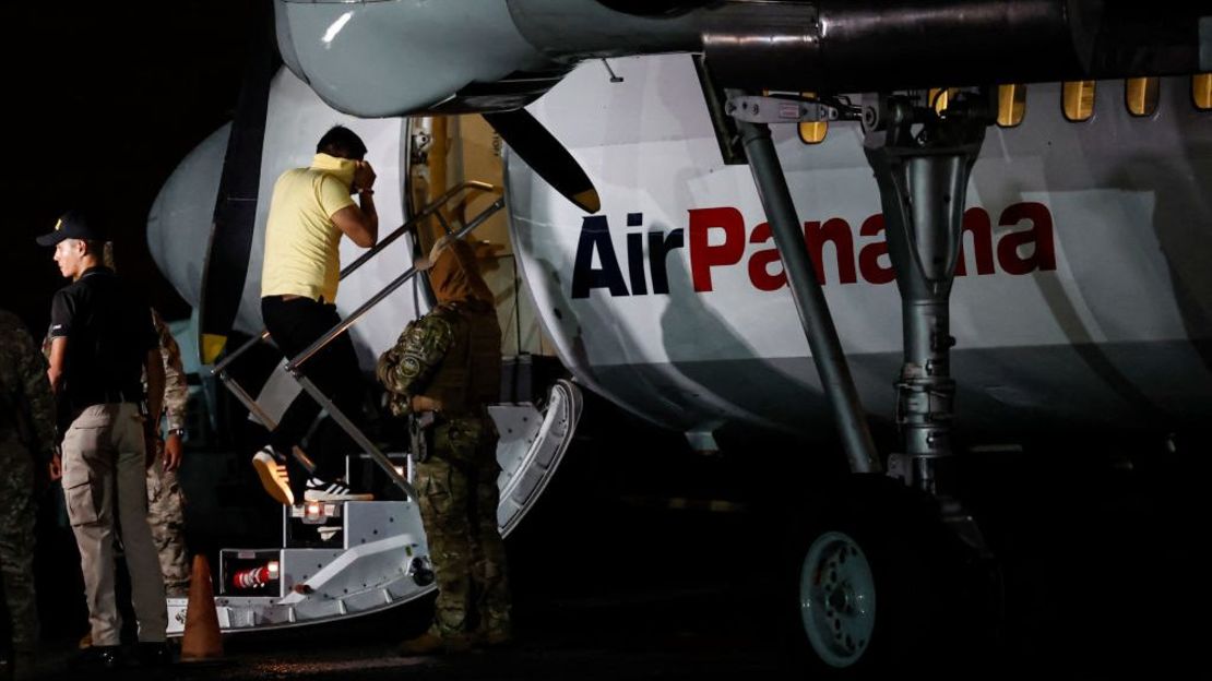 Un migrante ecuatoriano, con las manos y pies esposados, sube a un avión en el aeropuerto Albrook Gelabert de la ciudad de Panamá el 29 de agosto de 2024, durante su deportación.