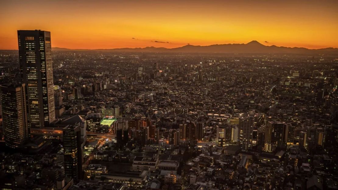 El monte Fuji se ve a lo lejos detrás del horizonte de Tokio al atardecer.