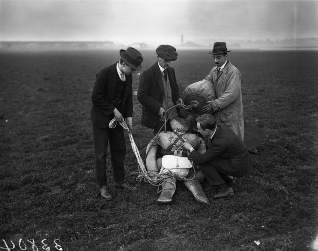 Expertos examinan un maniquí tras su caída en paracaídas desde un avión en el Aeródromo de Croydon. Crédito: Hulton Deutsch/Corbis/Getty Images