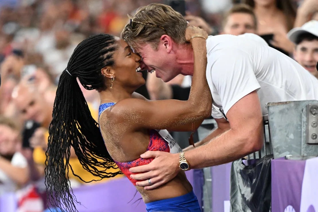 Tara Davis-Woodhall celebra con su marido Hunter Woodhall tras ganar el título olímpico en salto de longitud femenino en los Juegos de París 2024.