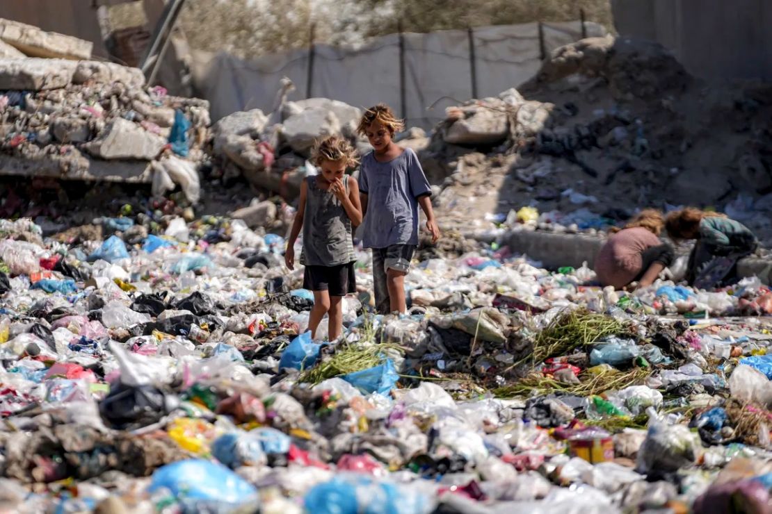 Niños desplazados examinan la basura en una calle de Deir Al-Balah, en el centro de la Franja de Gaza, el 29 de agosto.