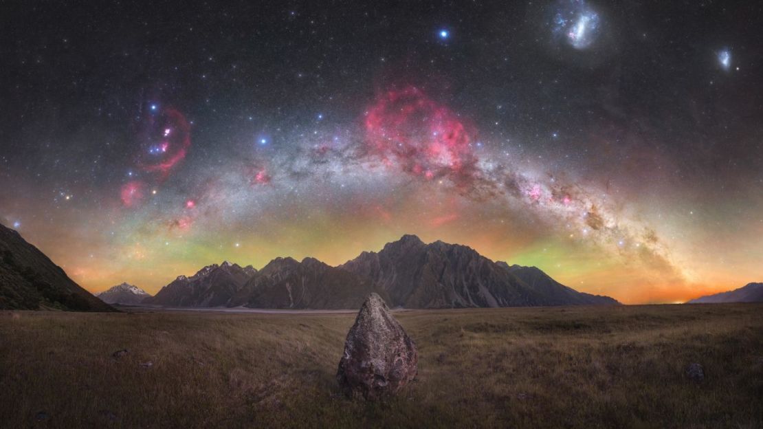 Tom Rae de Nueva Zelandia fue nombrado ganador de la categoría Skyscapes con esta fotografía de los picos del Valle de Tasmania bajo un cielo nocturno, con las nubes de hidrógeno de la Nebulosa Gum, que se puede ver en rojo en el centro.