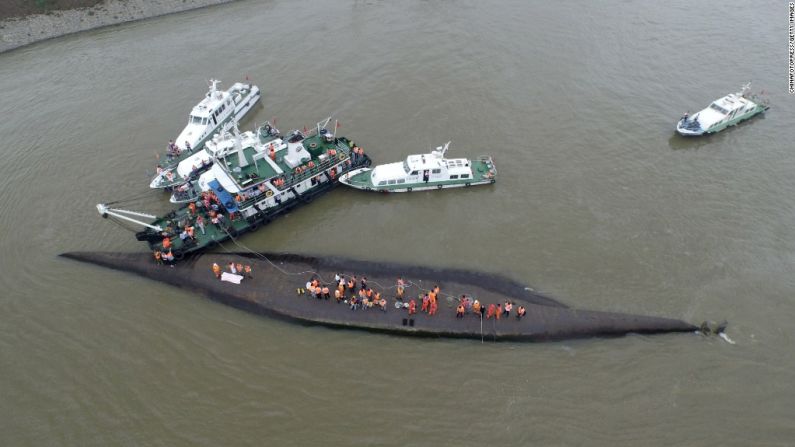 Un equipo de rescatistas está tratando de cortar la parte del barco que quedó boca arriba, sobresaliendo del agua.