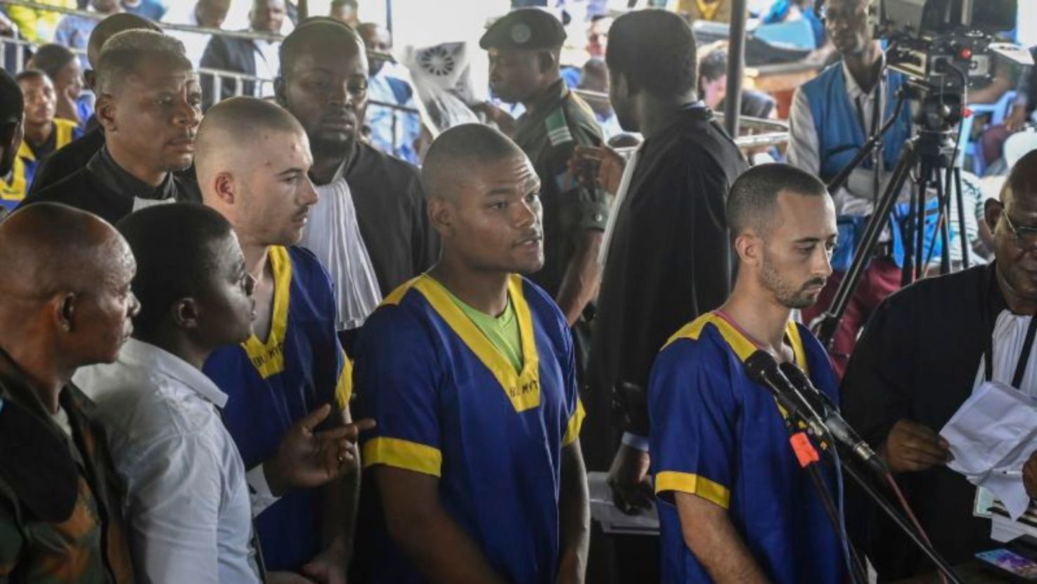 Tyler Thompson Jr., Marcel Malanga y Benjamin Reuben Zalman-Polun, todos ciudadanos estadounidenses, enfrentan al tribunal en Kinshasa con otros 52 acusados el 7 de junio de 2024. Crédito: Samy Ntumba Shambuyi/AP/Archivo