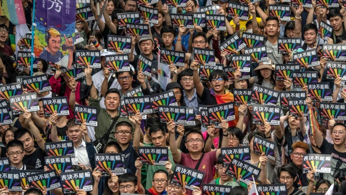 Personas sostienen carteles mientras se reúnen frente al parlamento de Taiwán antes de una votación sobre la legalización del matrimonio entre personas del mismo sexo el 17 de mayo de 2019 en Taipei, Taiwán.