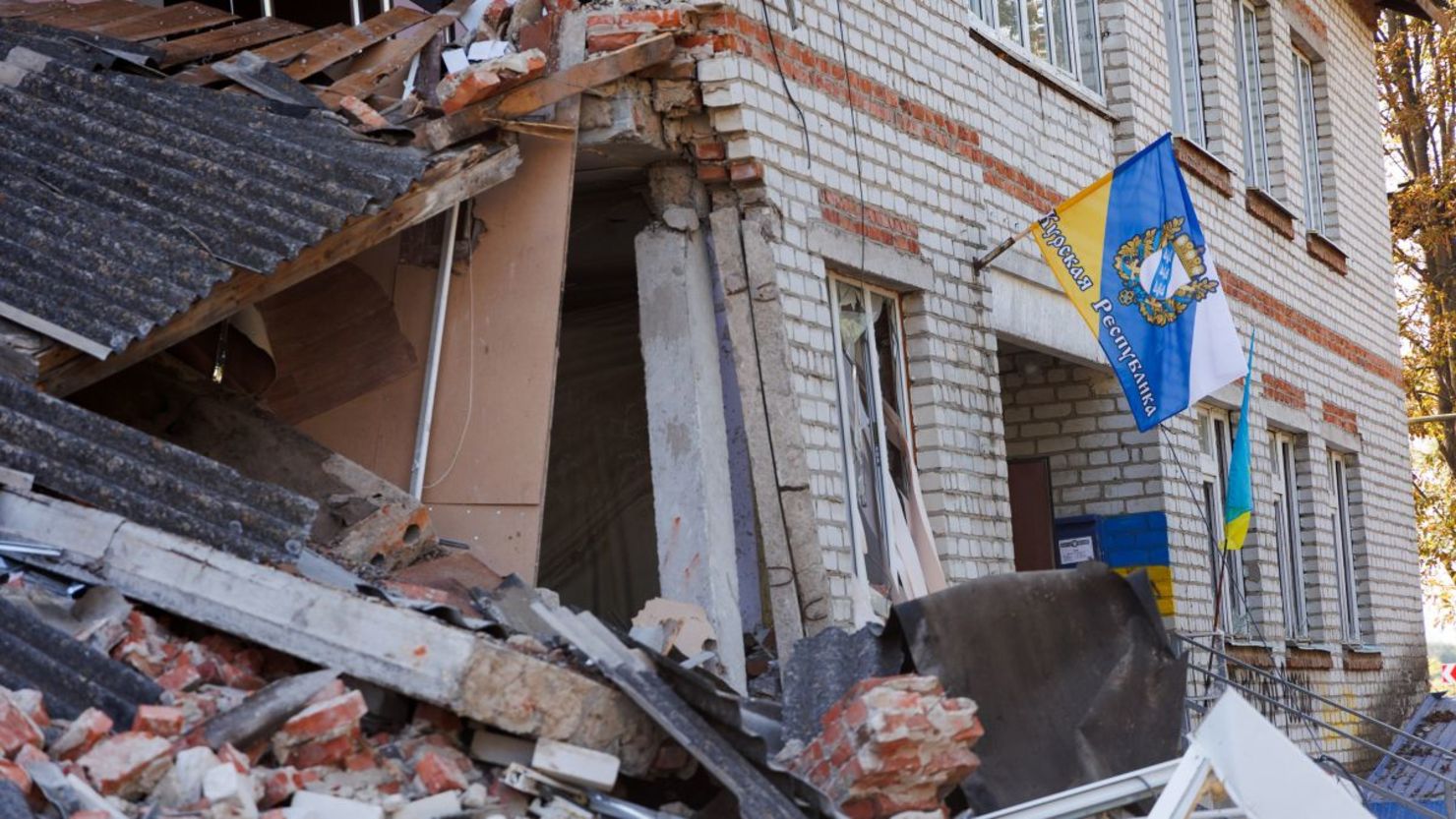 Una bandera con el escudo de armas de la región de Kursk se coloca en un edificio dañado el 10 de septiembre de 2024 en Sudzha, región de Kursk, Rusia.