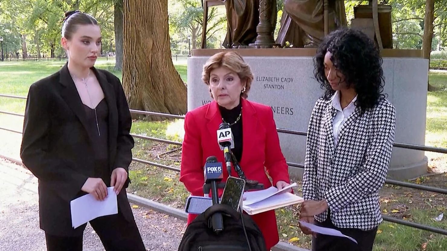 Flanqueada por Veronika Didusenko, izquierda, y Danielle Hazel, derecha, la abogada Gloria Allred, centro, habla durante una conferencia de prensa el 16 de septiembre de 2024, en Nueva York.