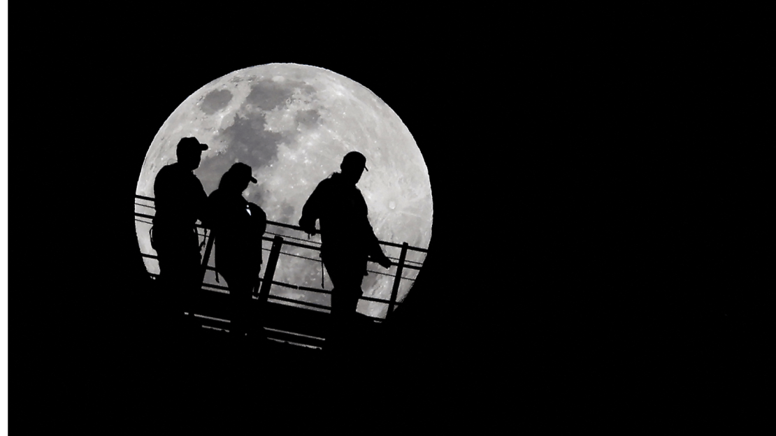 Personas observan la Luna llena mientras descienden desde la cima del Puente del Puerto de Sydney el 17 de septiembre de 2024.