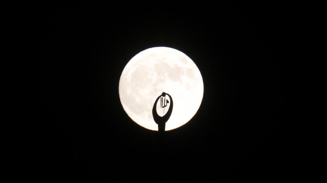 El minarete de una mezquita se ve a contraluz de la Luna llena en la ciudad de Hebrón, en la ocupada Ribera Occidental, el 17 de septiembre de 2024.